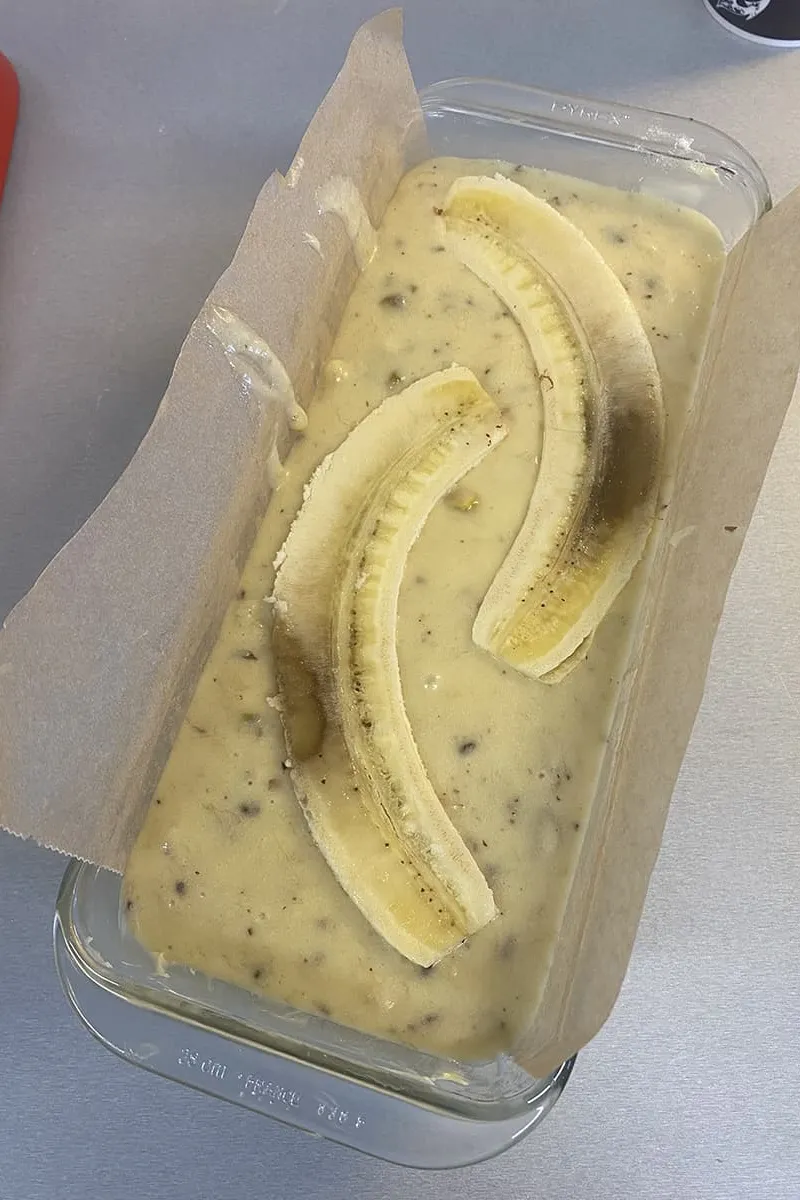 Gehalveerde bananen bovenop het bananenbrood