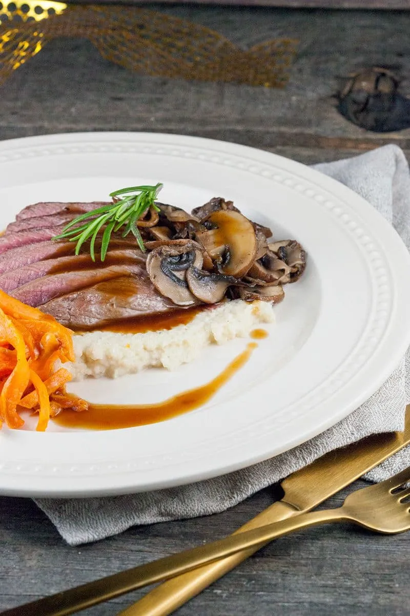Hertenbiefstuk met geroosterde bloemkoolpuree en zoete aardappelfrietjes